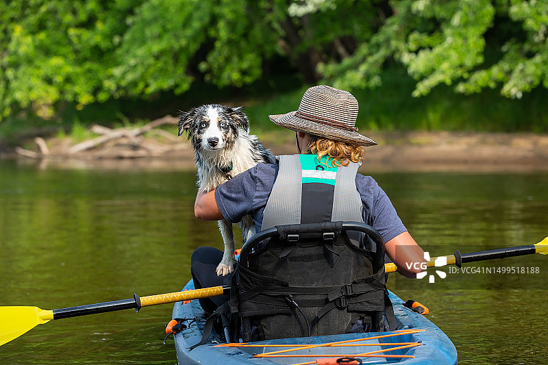 夏天里女孩和小狗在朗姆河上划皮划艇图片素材