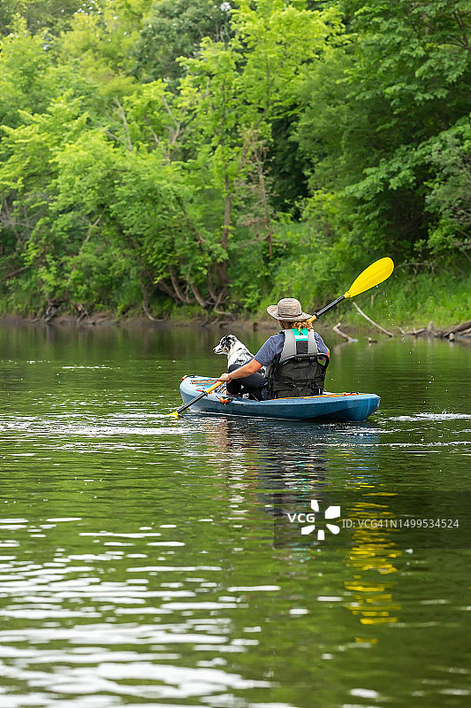 夏天里女孩和小狗在朗姆河上划皮划艇图片素材
