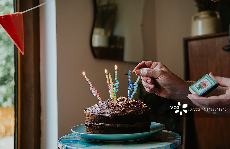 男人点燃生日蛋糕上的蜡烛图片素材