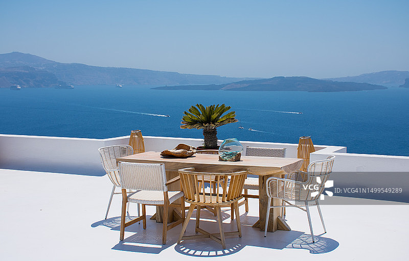 圣托里尼的白色露台上摆放着桌椅，可欣赏爱琴海浪漫海景的家具图片素材