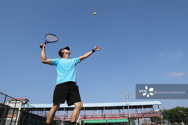 网球运动员在网球场上发球图片素材