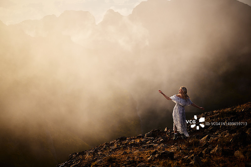 在雾天里在山上玩耍的快乐女人图片素材