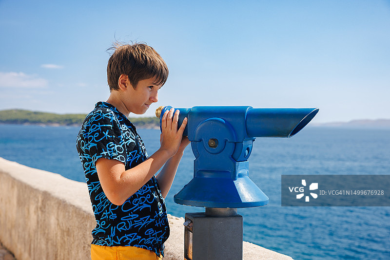 夏季海边小镇，用望远镜眺望的男孩图片素材