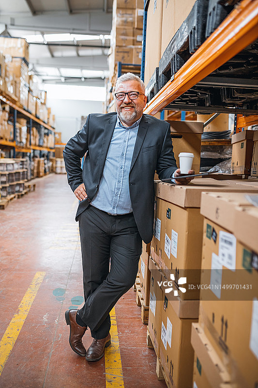 高效工厂管理：微笑的资深经理或首席执行官使用平板电脑监控工业工厂仓库中的生产情况图片素材