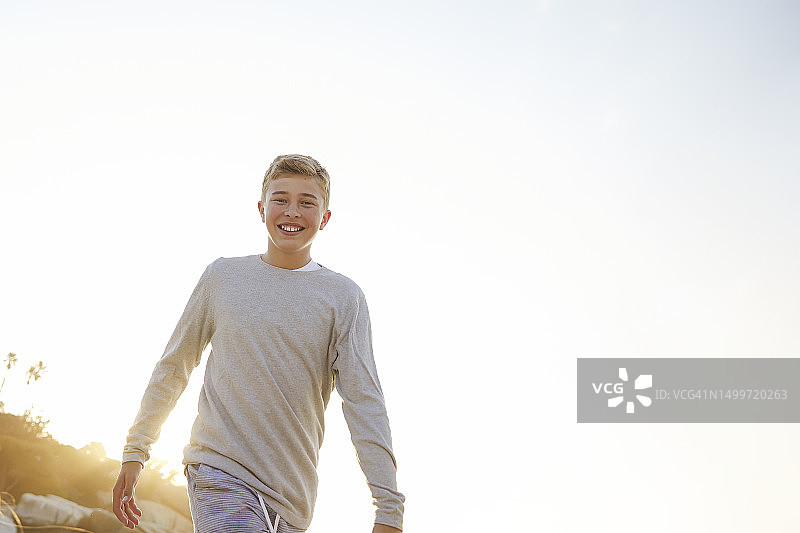 在海滩上行走的快乐少年图片素材