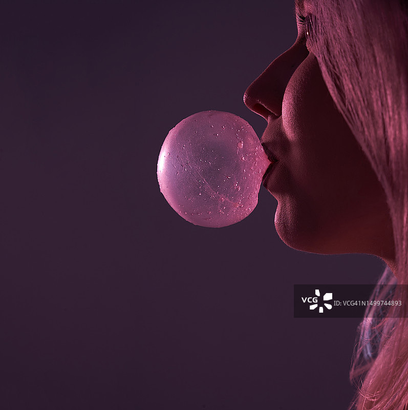 少女在紫色背景前吹泡泡糖泡泡图片素材