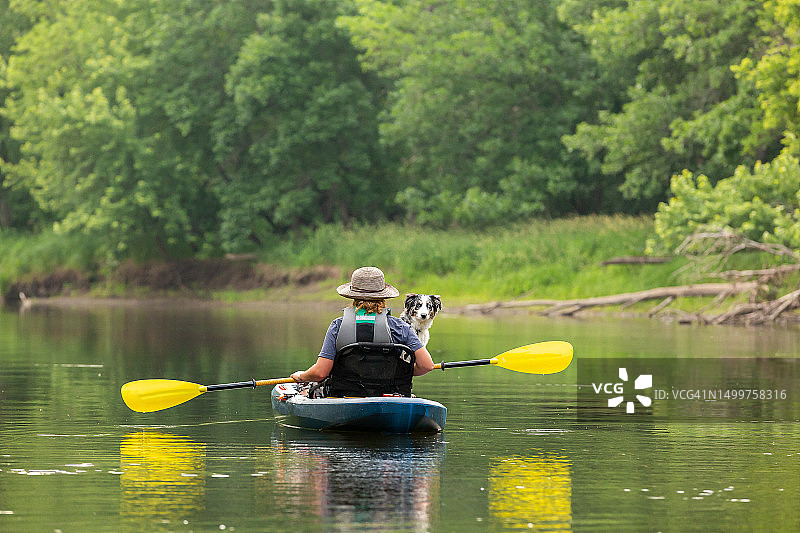 夏天里女孩和小狗在朗姆河上划皮划艇图片素材