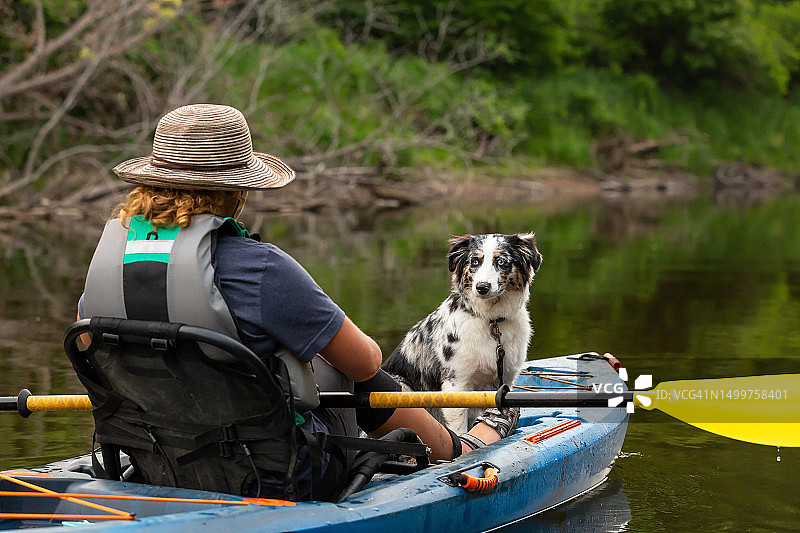 夏天里女孩和小狗在朗姆河上划皮划艇图片素材