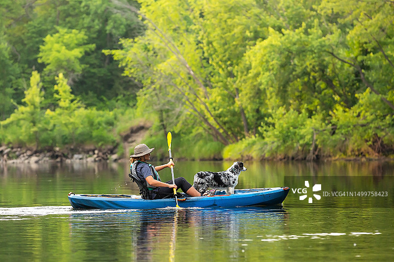 夏天里女孩和小狗在朗姆河上划皮划艇图片素材