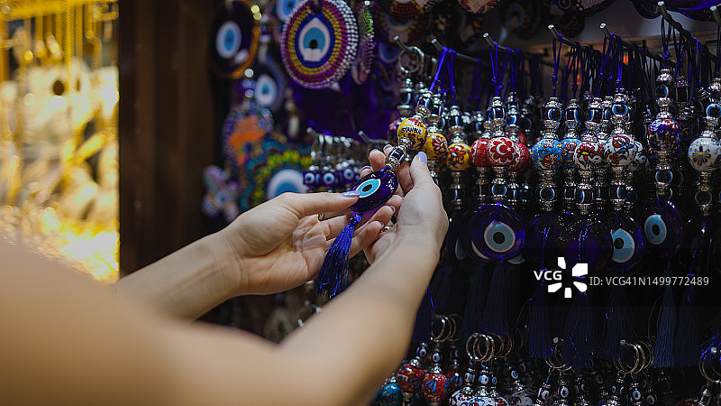 年轻女游客在伊斯坦布尔大巴扎挑选邪恶之眼护身符图片素材