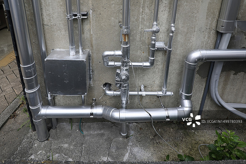 混凝土墙上的银色管道图片素材