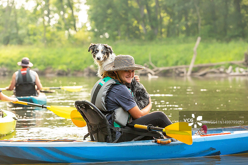 夏天里女孩和小狗在朗姆河上划皮划艇图片素材