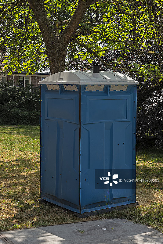 草坪上的蓝色移动厕所图片素材