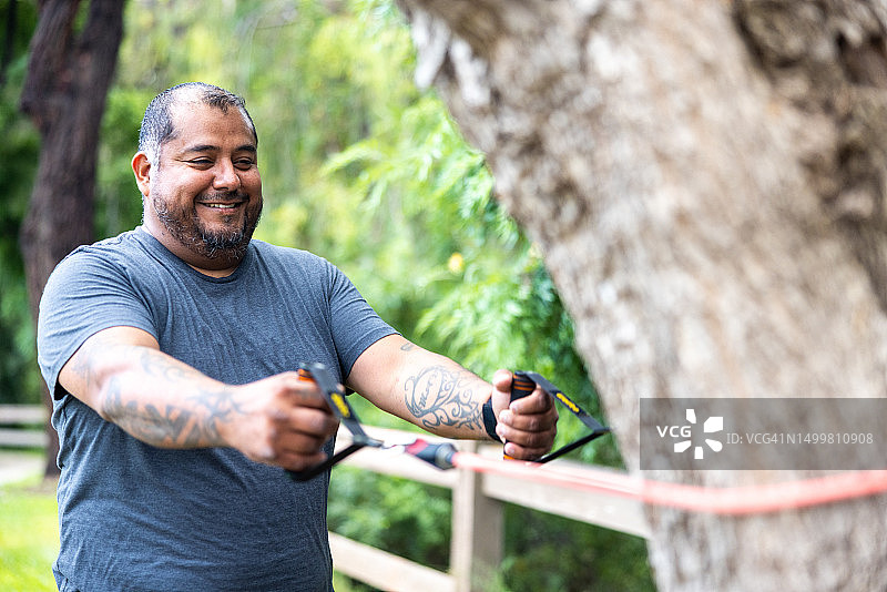 与阻力带一起锻炼的残疾西班牙裔退伍军人图片素材