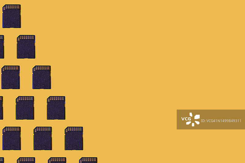 黑色SD存储卡数据存储图案，左侧，黄色背景。保存、存储、数据、计算、摄影和记忆概念图片素材