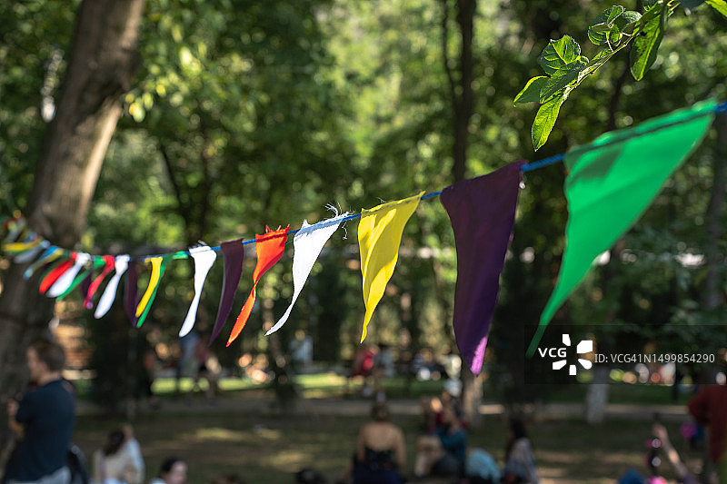 公园里的街头节日：悬挂在绿树间的彩旗图片素材