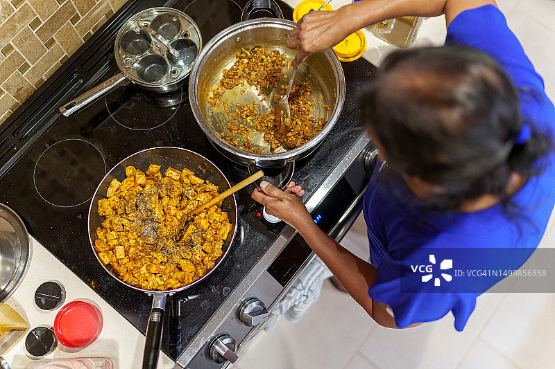 年长的女人在家烹饪传统印度美食图片素材