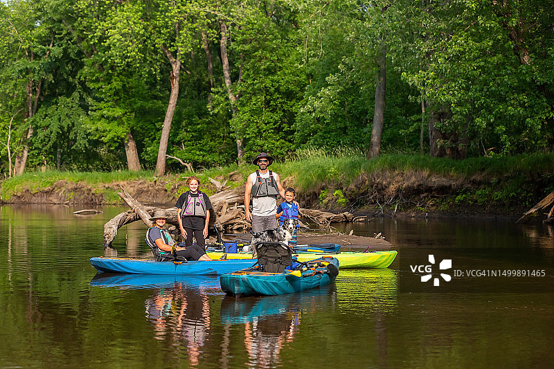 家庭和狗在沙洲上与皮划艇图片素材