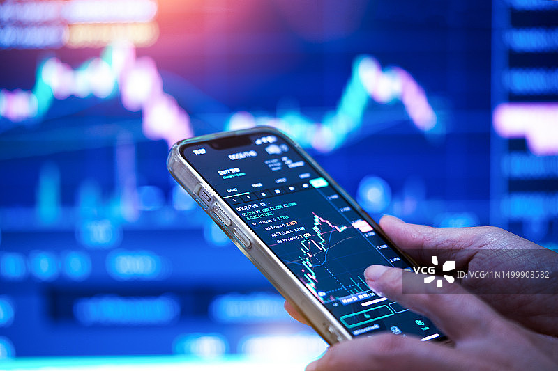 拿着手机查看股市数据的女商人图片素材
