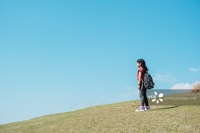 小女孩在奈良若草山游玩，背景为蓝天，旅行概念图片素材