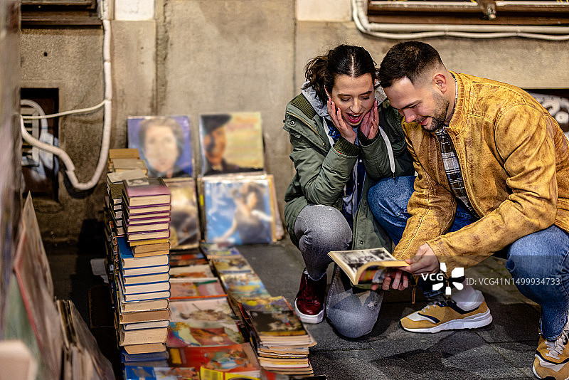 年轻情侣沉浸在古籍和唱片的历史与艺术中图片素材