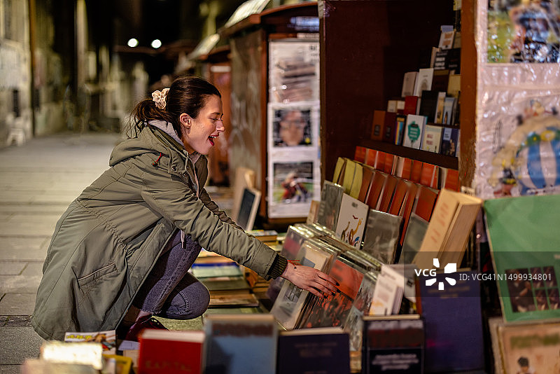 在街上寻找独特书籍和唱片的年轻女人图片素材