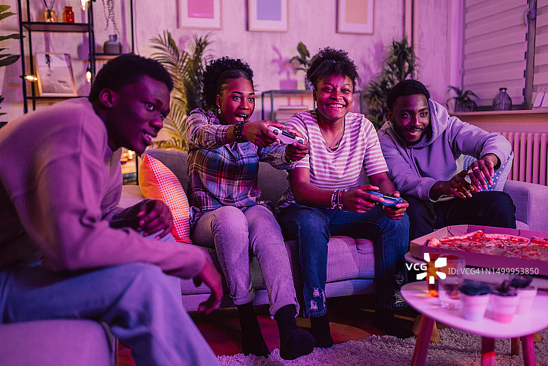 夜晚，朋友们在家玩电子游戏图片素材