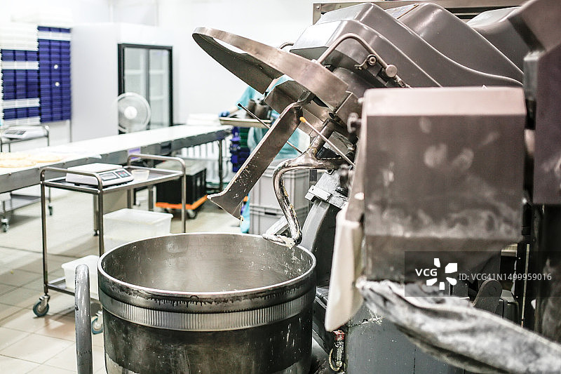 食品工厂大型机器中的面团揉捏过程图片素材
