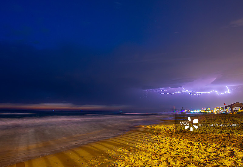 暴风雨天气下夜晚的地中海海滩与远处闪电图片素材