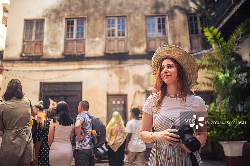 快乐的年轻女游客用相机拍照图片素材