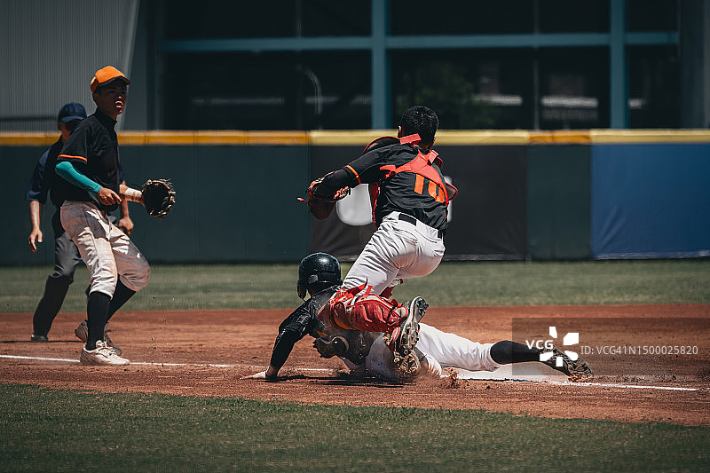 棒球赛：跑垒员被捕手在三垒夹杀的关键时刻图片素材