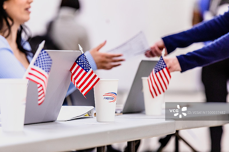 女性投票站志愿者向无法辨认的选民分发选票图片素材