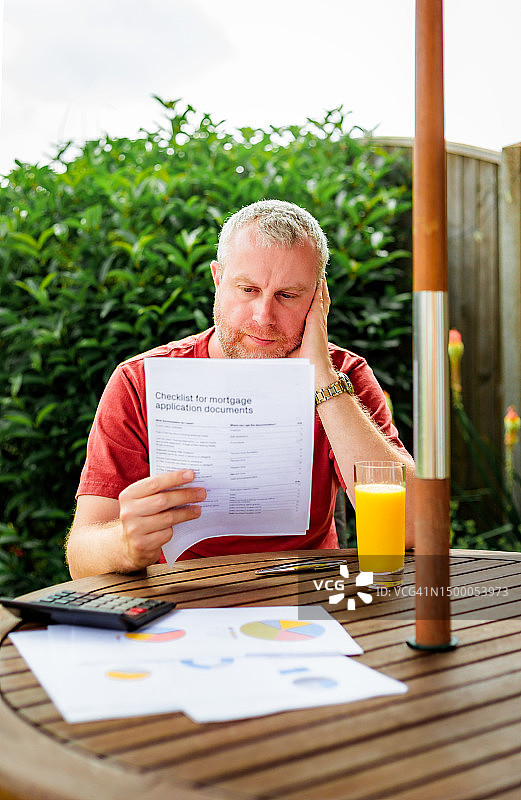 男人阅读抵押贷款申请文件图片素材