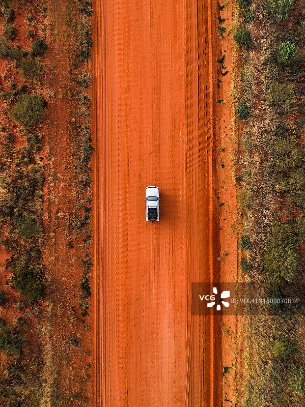 航拍照片：一辆四驱车行驶在澳大利亚北部地区塔纳米沙漠的波纹土路上图片素材