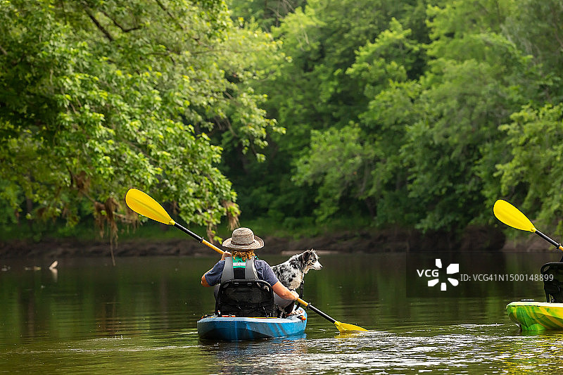 夏天里女孩和小狗在朗姆河上划皮划艇图片素材