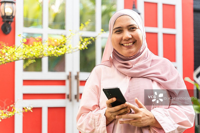 在露台户外使用智能手机的亚洲女人图片素材