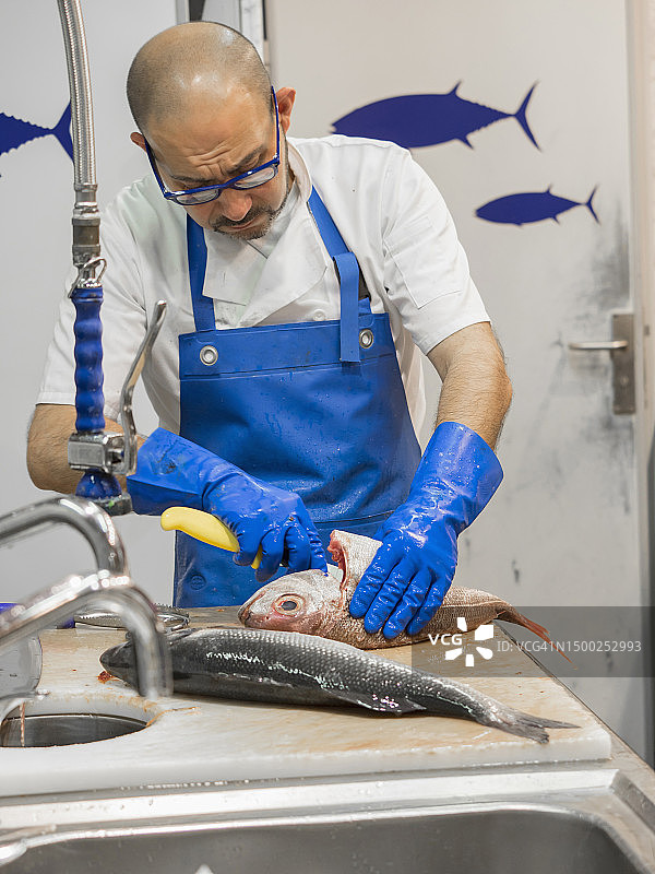 男人用刀准备鱼图片素材