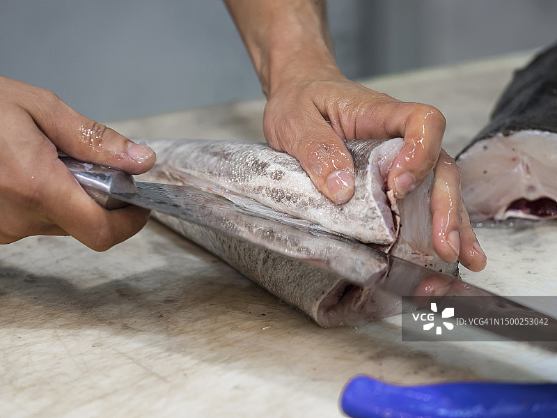 男人用刀切鱼图片素材