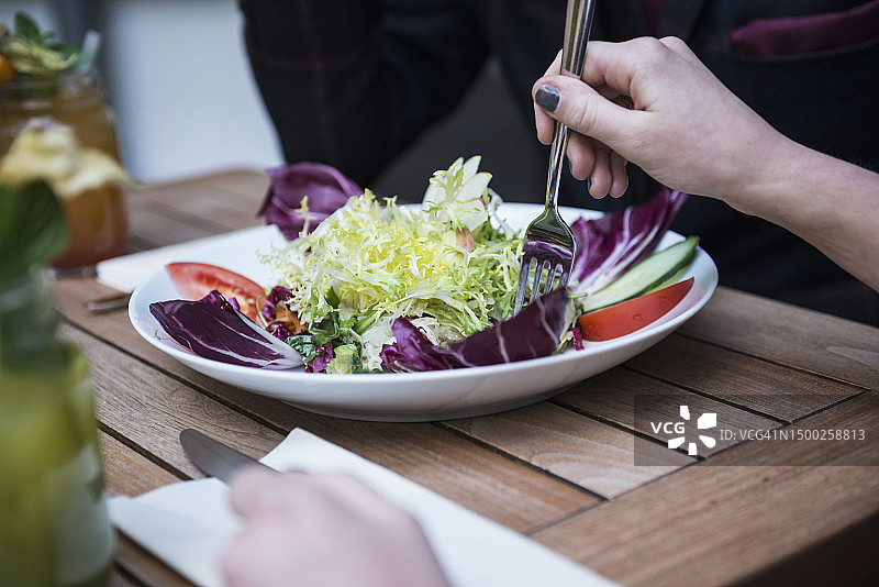 女性手持叉子吃沙拉图片素材