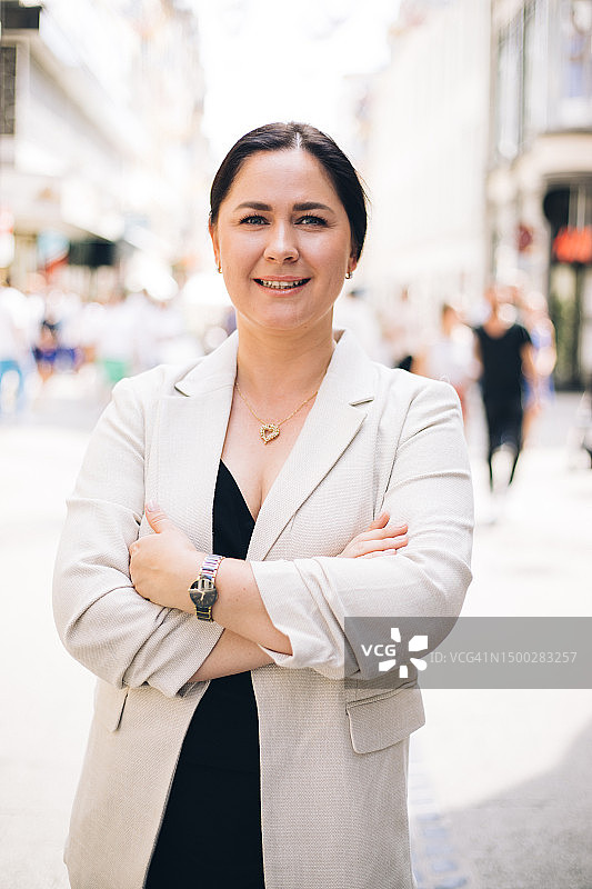 自信的中年职业女性站在市中心街道上看镜头图片素材