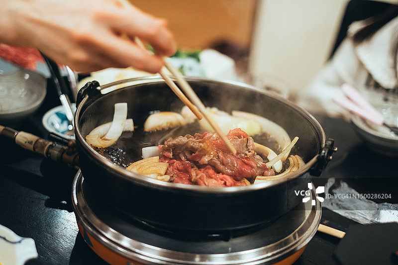 年轻亚洲女性在餐厅享用牛肉火锅美食图片素材