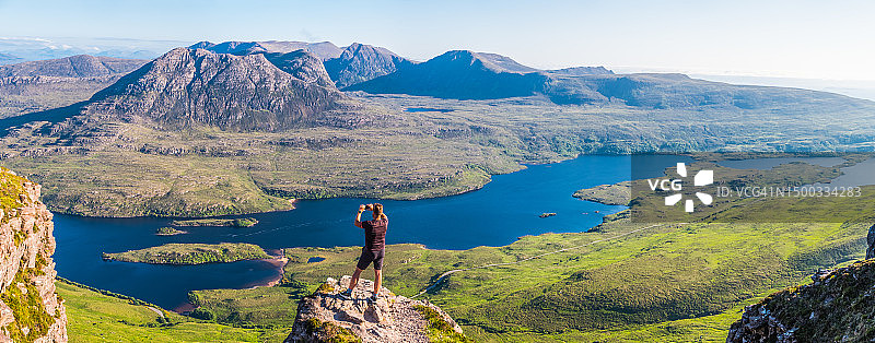 徒步者在苏格兰高地山顶拍摄荒野全景图片素材