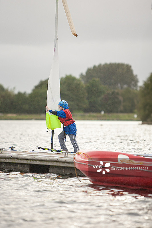 十一岁女孩在湖上学习帆船课程后收帆图片素材