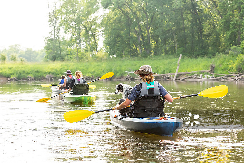 一家人和狗在夏季的朗姆河上划皮划艇图片素材