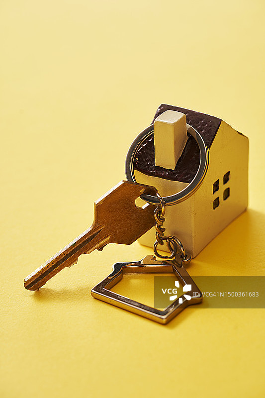 黄色背景下桌子上的钥匙特写图片素材