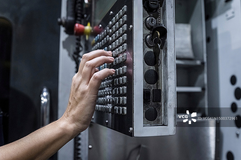 维修工程师在现代工厂操作数控机床图片素材