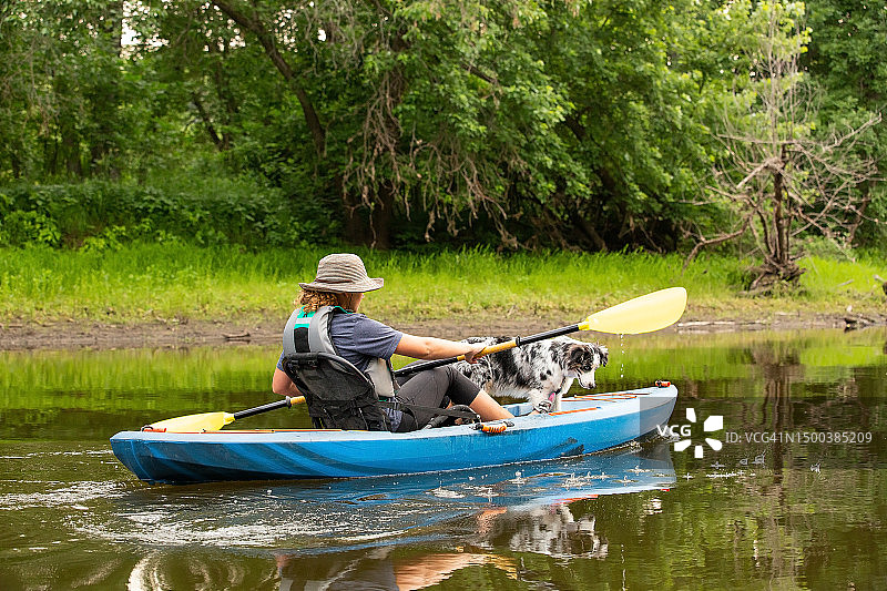 夏天里女孩和小狗在朗姆河上划皮划艇图片素材