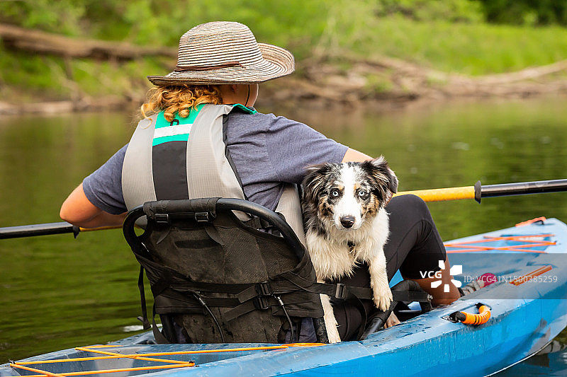 夏天里女孩和小狗在朗姆河上划皮划艇图片素材