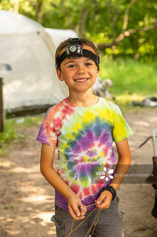 在树林里露营时戴着头灯的男孩图片素材