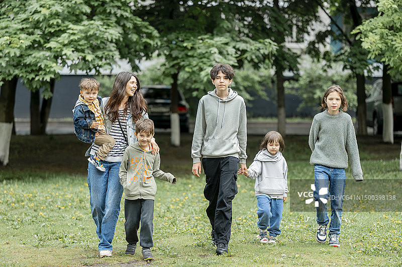 快乐的母亲和孩子们在公园里散步图片素材